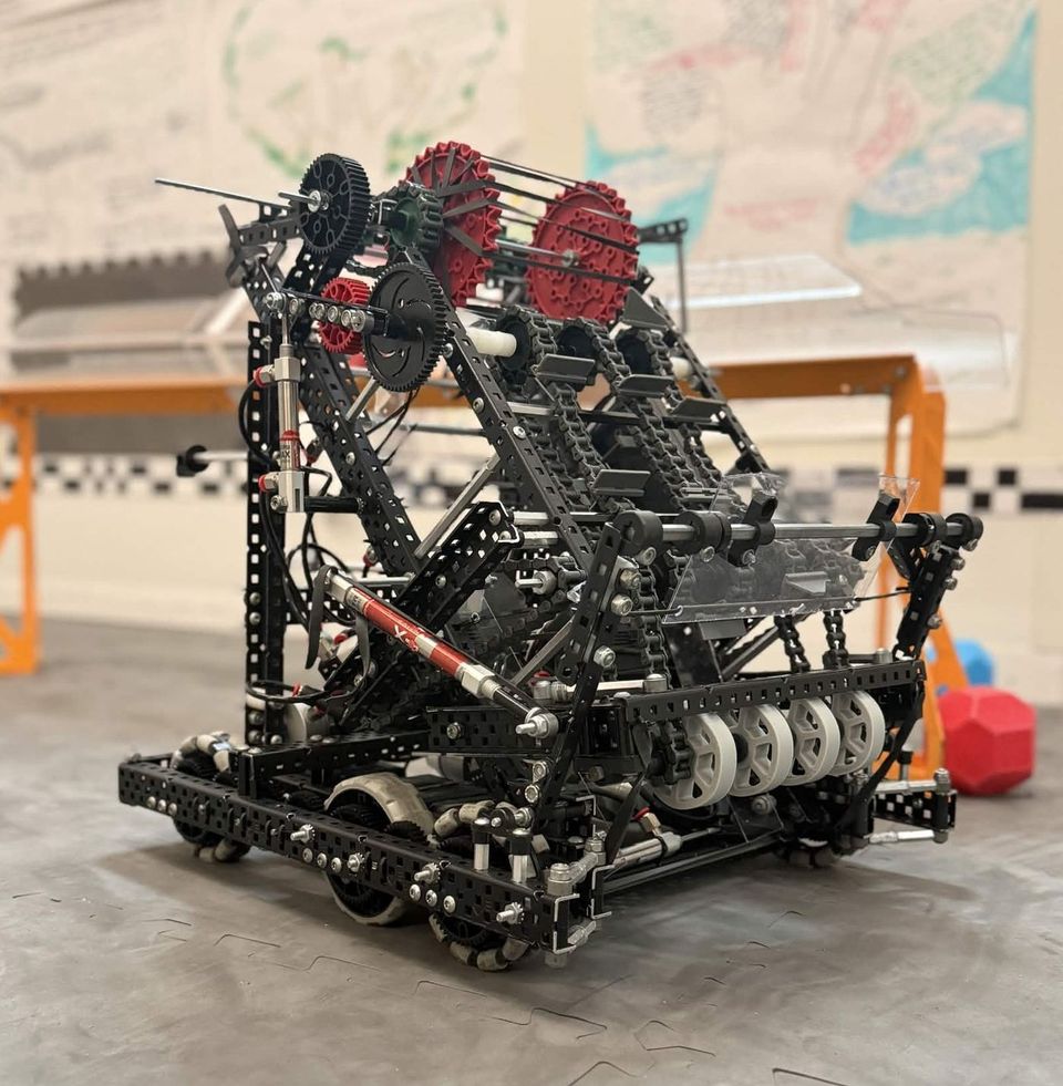 285C's Push Back robot: a black aluminum frame with red sprockets, a chain-driven conveyor angled up the front, and omni wheels.